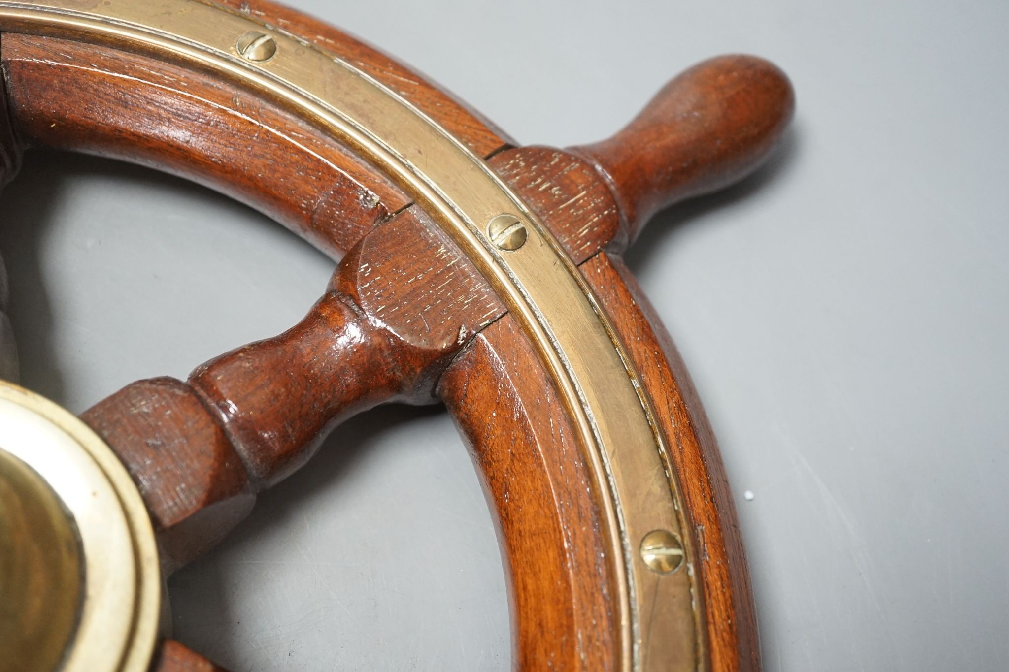 A teak and brass mounted Ship's wheel signed Lawrence Simpson 47cm